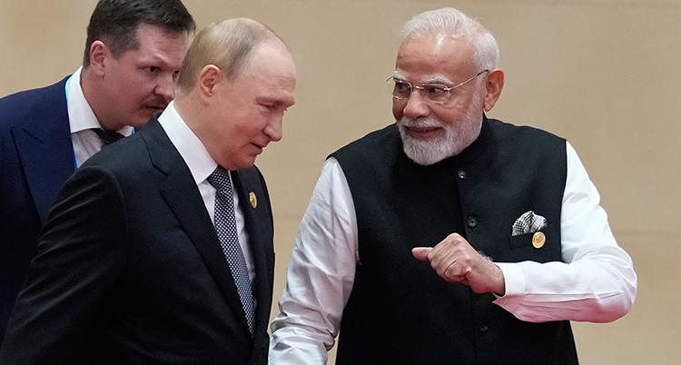 Vladimir Putin och Narendra Modi går bredvid varandra. Modi ser glad ut.