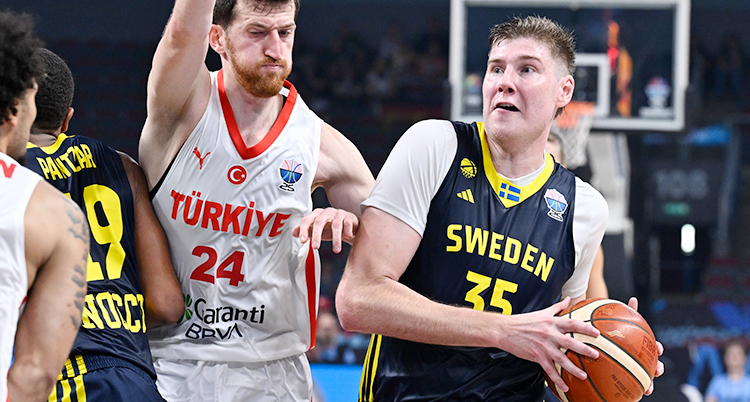 Från en match i basket. Den svenska spelaren har bollen. En turkisk spelare försöker stoppa honom.