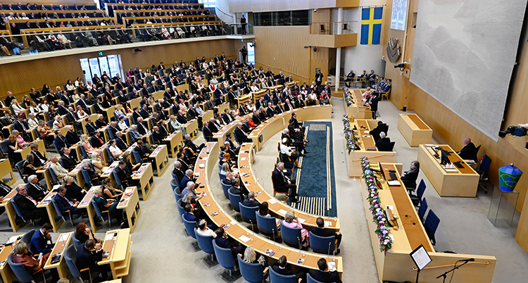 En stor sal där riksdagens politiker sitter i sina bänkar.