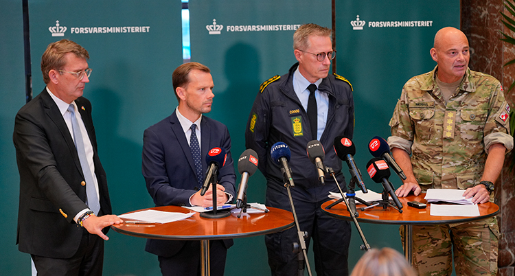 Fyra män håller presskonferens.
