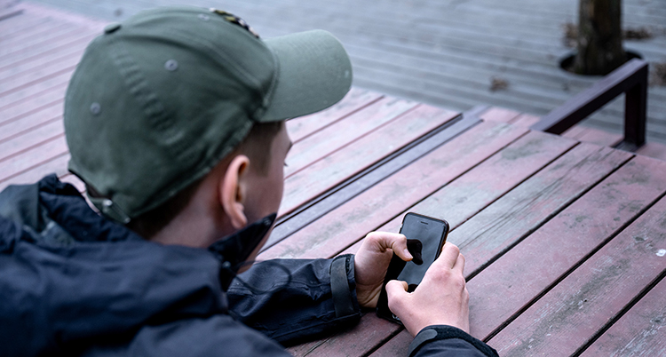 En ung kille med en mobiltelefon.
