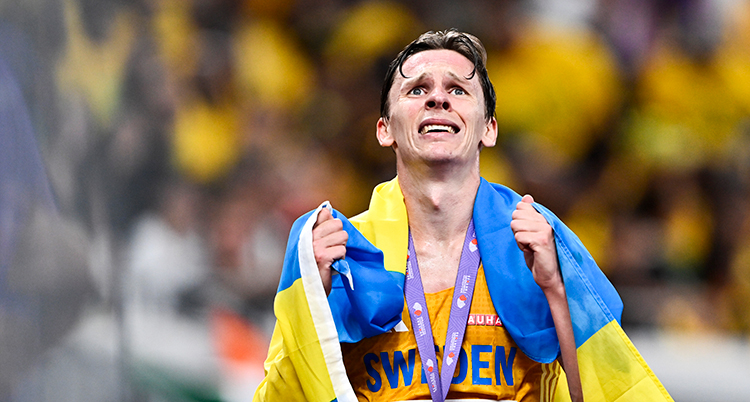 Han har medaljen och den svenska flaggan runt halsen.