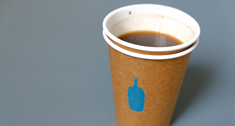 Två pappmuggar som sitter ihop. Det är kaffe i.