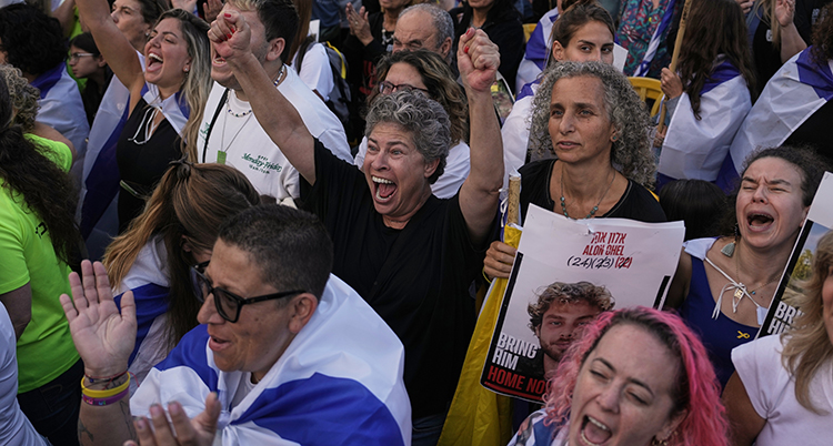 Många människor står på ett torg i staden Tel Aviv. De skriker och jublar och sträcker händerna i luften.