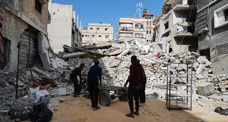 Ett hus är helt trasigt. Några personer är där och röjer och städar.