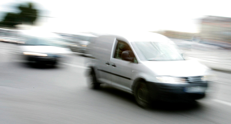 En suddig bild på en grå bil som kör på en gata.