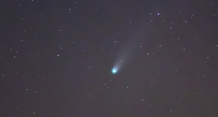 Ett vitt ljus som ser ut som en stjärna med svans syns på himlen.