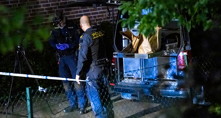 Två poliser undersöker platsen.
