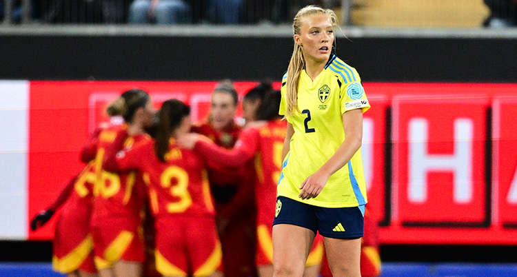 Hon deppar. I bakgrunden kramas flera spelare i Spaniens lag.