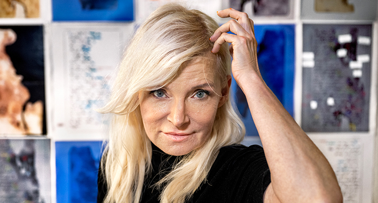Porträtt. Hon tittar in i kameran. Hon har långt blont hår.