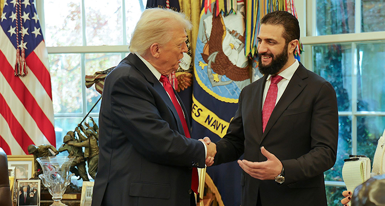Donald Trump och Ahmed al-Sharaa står inne i Vita huset och skakar hand med varandra. Ahmed al-Sharaa är glad.