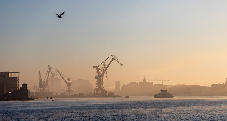 En bild från hamnen i Göteborg med stora kranar.