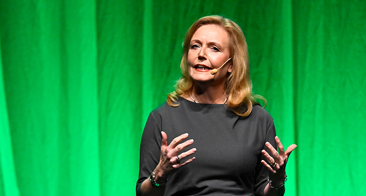 Hon står på en scen och pratar.