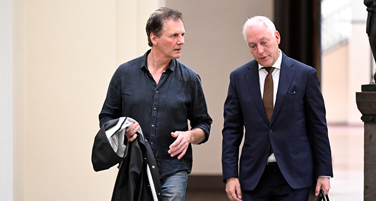 Två män går bredvid varandra.