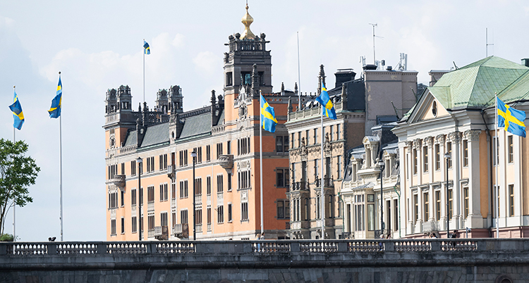 En gammal byggnad. Sveriges flaggor syns utanför.