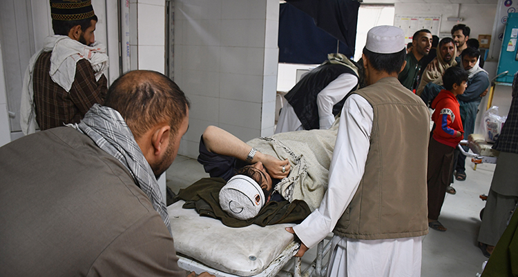 Människor runt en man på en brits.