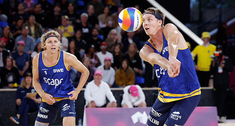 Bild från en match. Hellvig slår en boll med båda armarna. Åhman tittar på i bakgrunden.