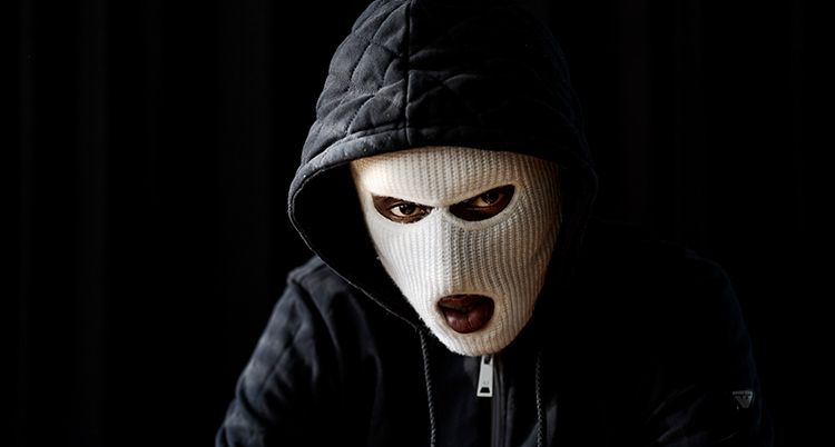 Ett porträtt. Han har en vit mask för ansiktet.