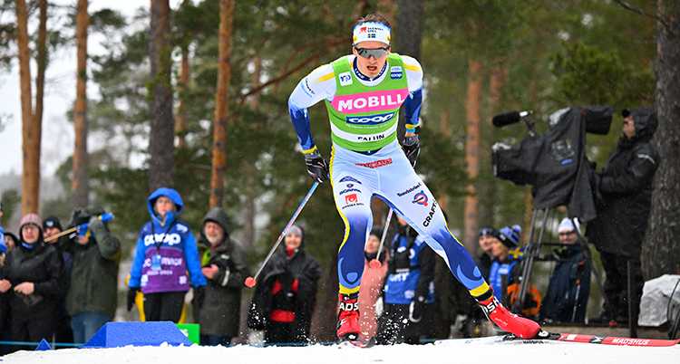 Han åker skidor i en tävling.