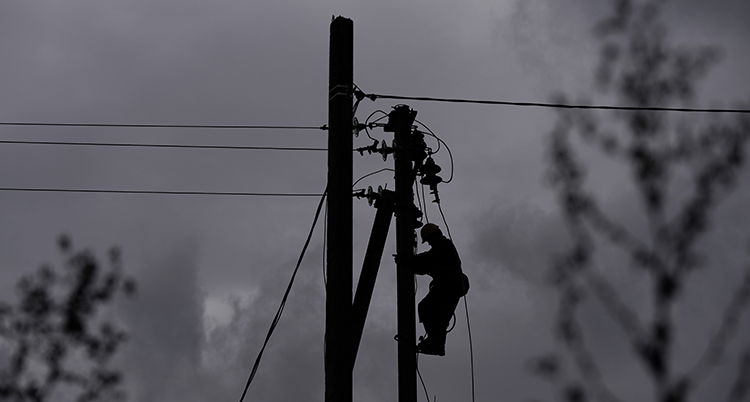 En man klättrar på en elstolpe.