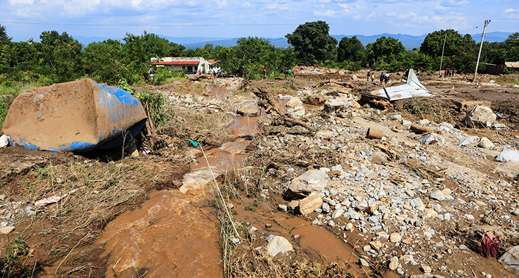 Leriga vägar och förstörda hus. En båt ligger upp och ned.
