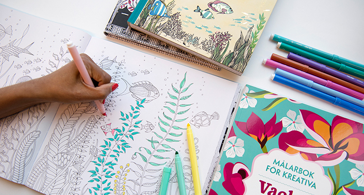 En hand fylleri ett mönster i en målarbok.
