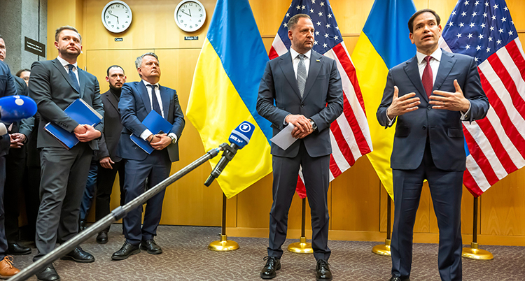 De står bredvid varandra. Bakom dem syns Ukrainas och USAs flaggor.