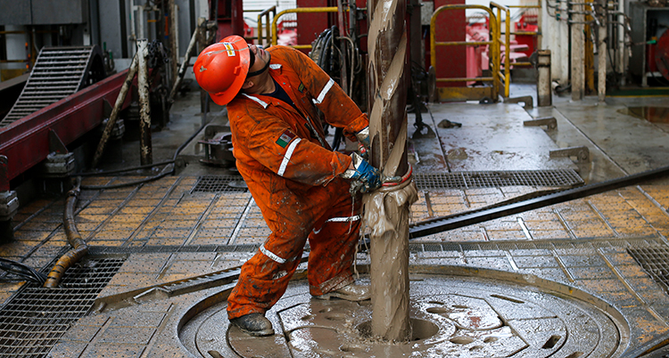 En arbetare vid en stor borr.