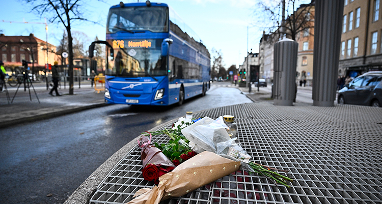 Blommor ligger på trottoaren.