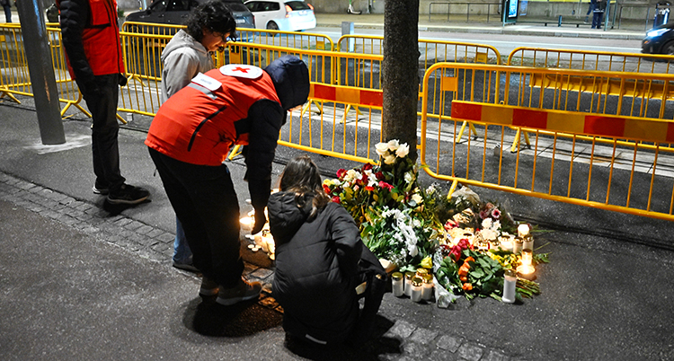 De lägger blommor på marken.