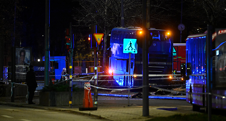 Det är mörkt. En buss syns. Polisernas tejp har spärrat av platsen.