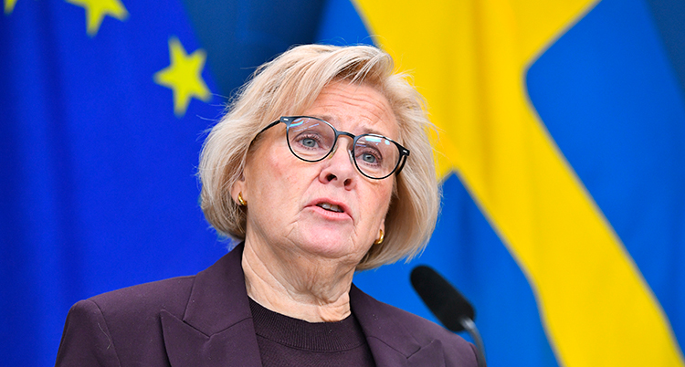 Hon har kort hår och glasögon.