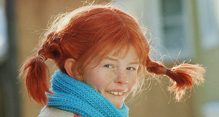 Hin tittar in i kameran och ler.