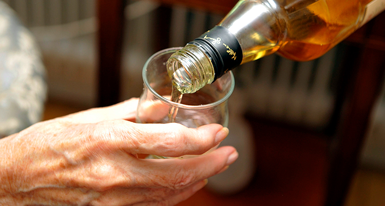 En person som häller upp sprit till en annan person.