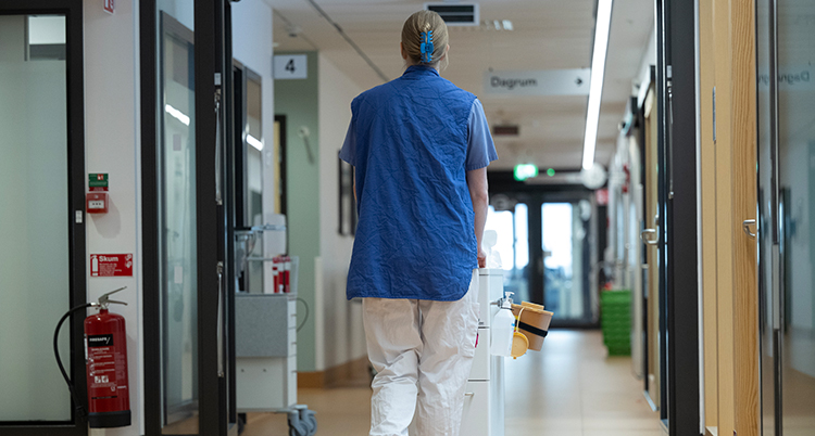 En sköterska går i en korridor.