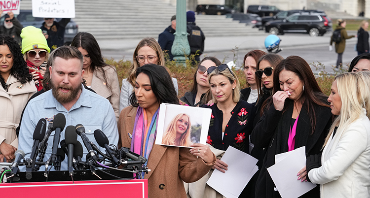 Fler människor. En kvinna håller upp ett foto.