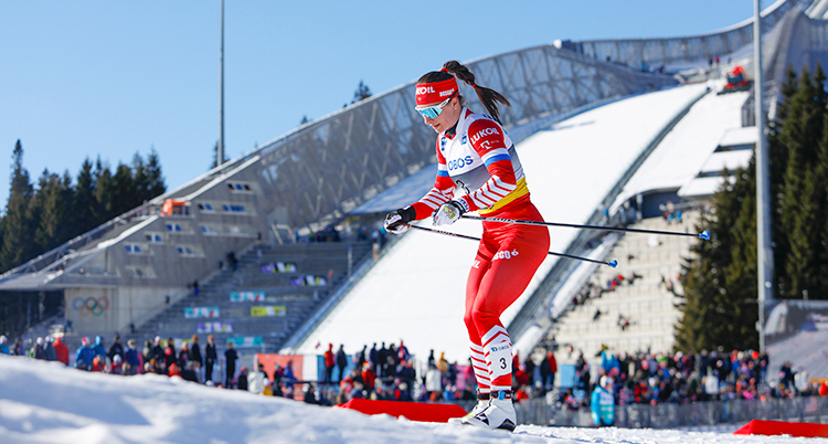 Hon åker längdskidor i en tävling.