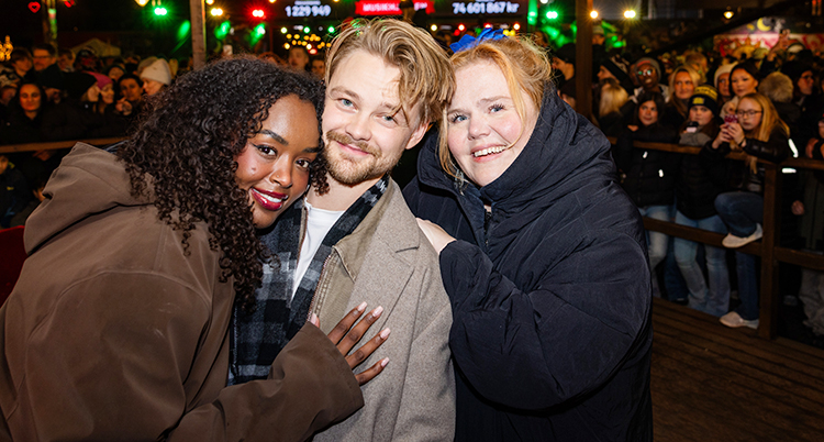 De är glada. De står bredvid varandra och tittar in i kameran.