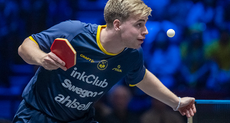 Han ska slå en serve i bordtennis.