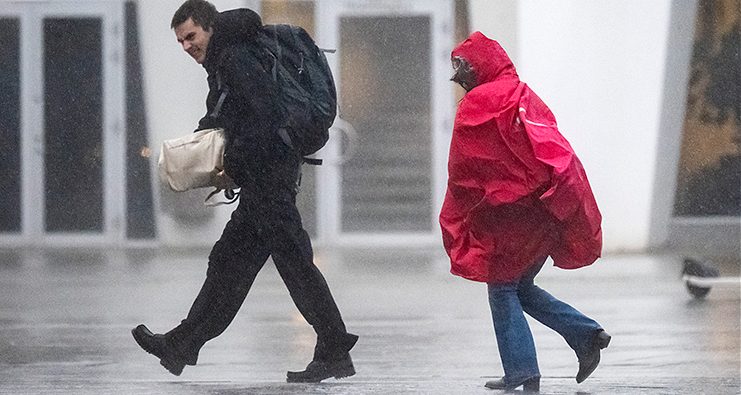 Två människor går i regnet.