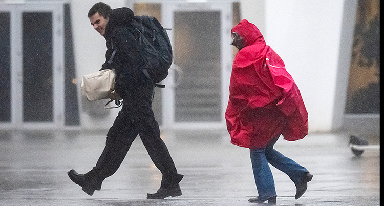 Två människor går i regnet.