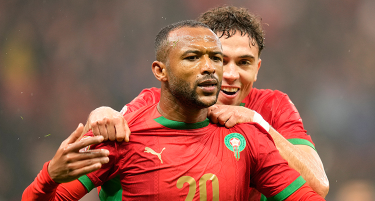 En spelare blir gratulerad av en annan spelare. De har röda tröjor.