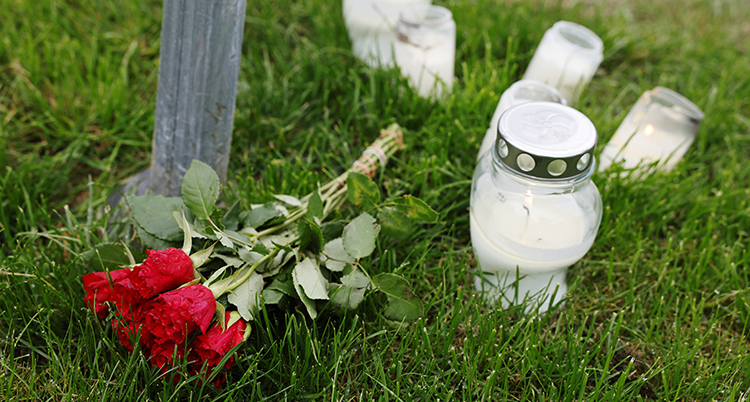 Blommor och ljus på en gräsmatta.