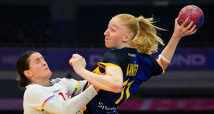 Hon hoppar och laddar för skott. En norsk spelare försöker hålla emot.