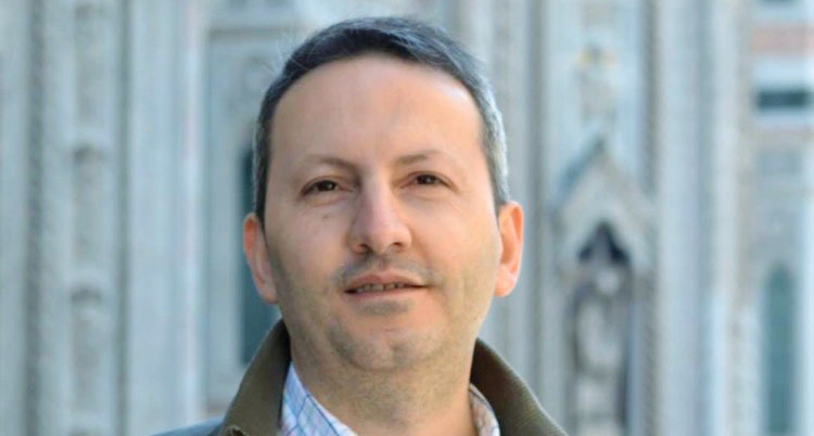 Han ser glad ut. Han tittar in i kameran.