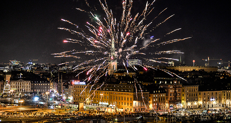 En raket exploderar med gnistor över staden.