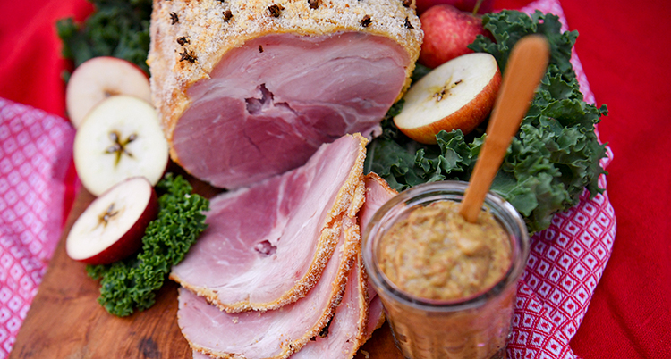 En bild på en skinka som skurits i flera skivor.