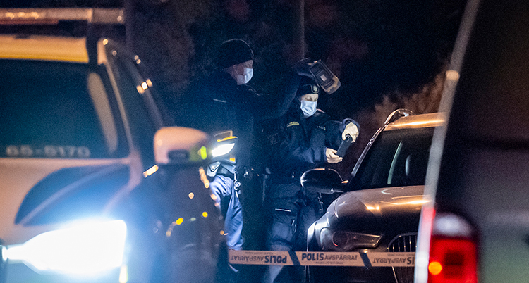 Det är mörkt. De har satt upp polistejp framför bilen.