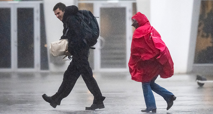 Två människor går i regnet.