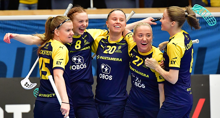 Flera spelare i blågula tröjor kramar om varandra. De är glada.